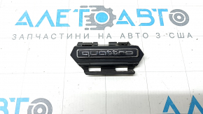 The emblem with the inscription "quattro" on the radiator grille of the Audi A5 F5 20-25 sand