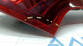 The outer right fender light of the Nissan Rogue Sport 17-19 is worn, missing a fragment, chip, cracks