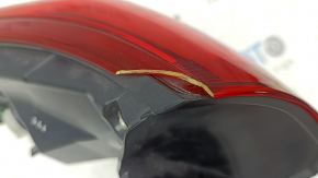 The outer right fender light of the Nissan Rogue Sport 17-19 is worn, missing a fragment, chip, cracks