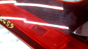 The outer right fender light of the Nissan Rogue Sport 17-19 is worn, missing a fragment, chip, cracks