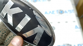 The emblem badge of the front bumper of the Kia Niro 17-22 has peeled off coating and swollen varnish