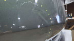 The trunk door is bare Kia Sportage 23-26 2.5 electric, green JUG, dented, covered in soot, scratches