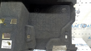 The rear floor covering of a BMW X3 F25 11-17 is black and needs cleaning. The foam rubber is torn and 2 mat fasteners are missing