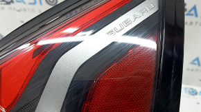 The outer right wing light of a Subaru Forester 25-26 is worn and has a spider web