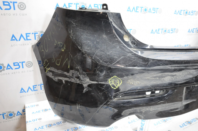 The rear bumper is bare and needs repair for a Mazda3 MPS 2009-2013. It's black and has a hole in it and a dent.