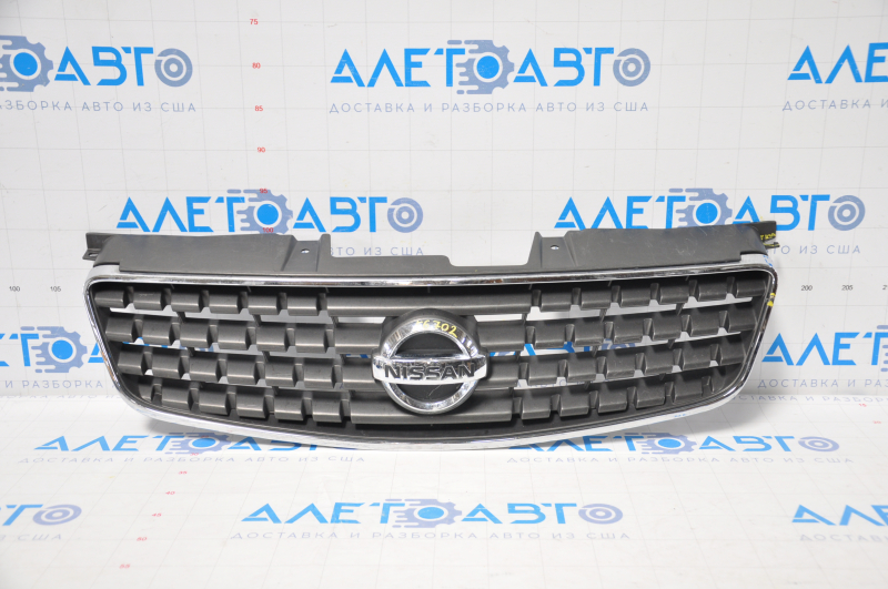 Nissan Alltima 2005 USA radiator grille has chrome breakage, tears, broken fasteners, torn guides, and a bump on the emblem.