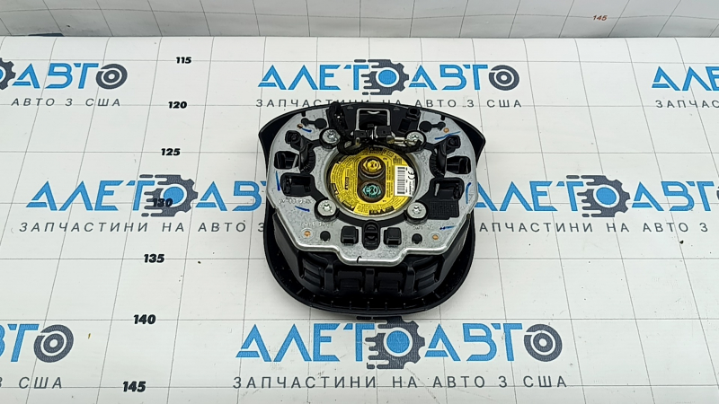 The driver's side airbag in the Jeep Grand Cherokee WK2 14-18 steering wheel is black, scratched, and has a rusty squib.