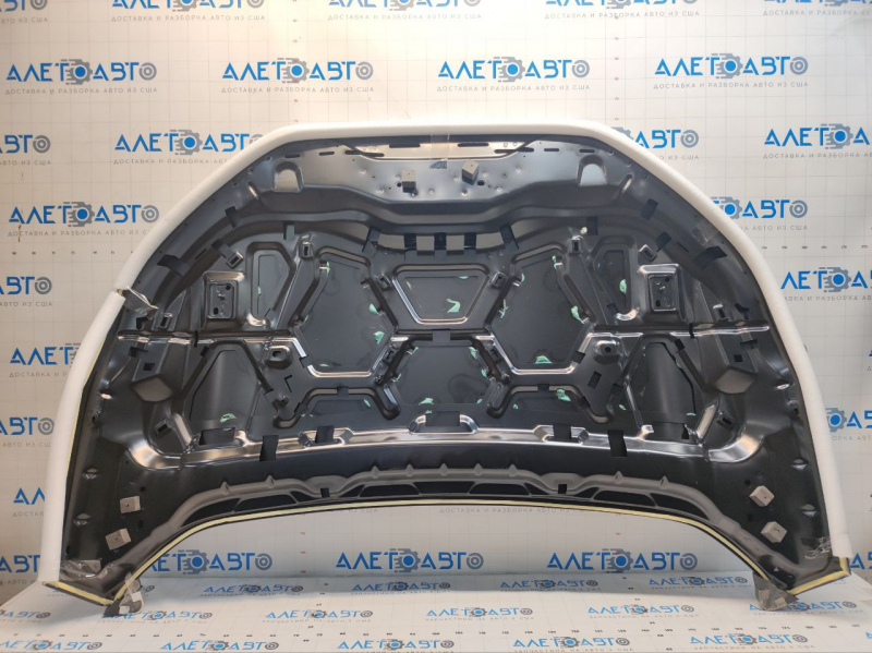 The hood of a Ford Edge 19-24 aluminum is bare and has a large dent.