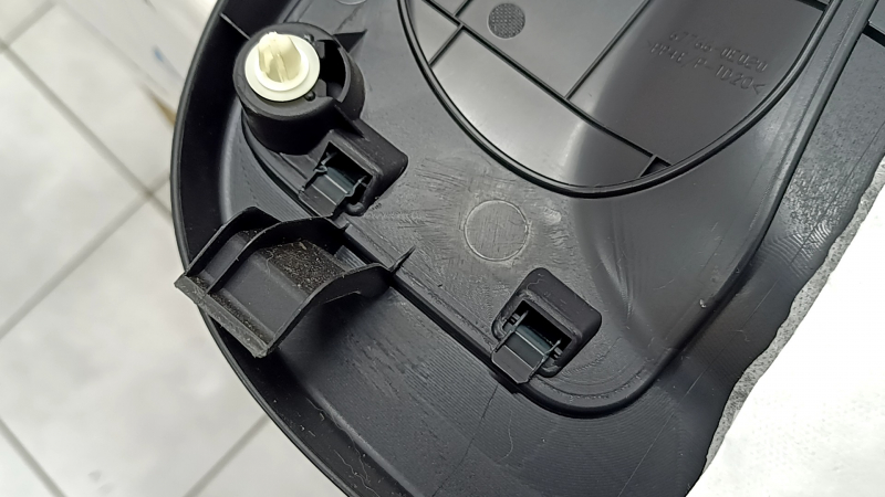 The trunk door trim of a 19-2019 Toyota Highlander is black, with plugs, scratches, and broken fasteners.