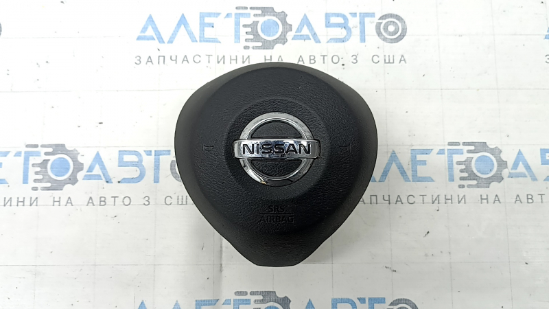 The driver's side steering wheel airbag for a Nissan Rogue 17-20 is black, has scratches, and is rusty.