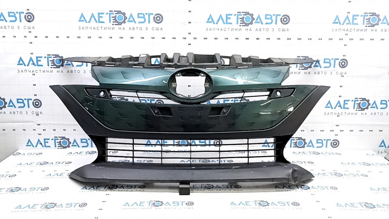 The radiator grill of a Toyota Prius 50 Prime 17-19 under parking sensors is cracked and dented.
