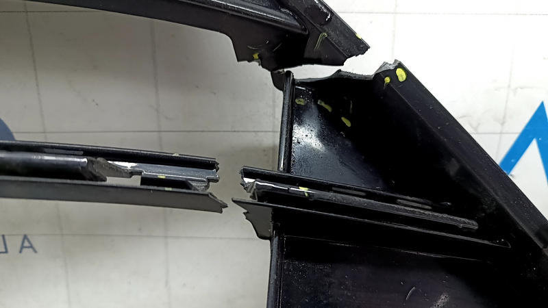 The lower grille of the front bumper, central, VW Tiguan 18-21, under parking sensors, R-Line, is cracked, chipped, and sanded.