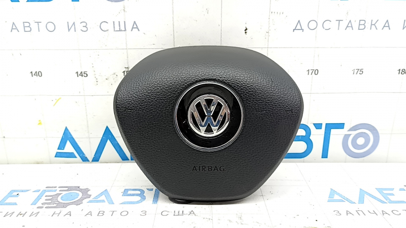 The driver's side airbag in the steering wheel of a VW Tiguan 18-21 is black and scratched.