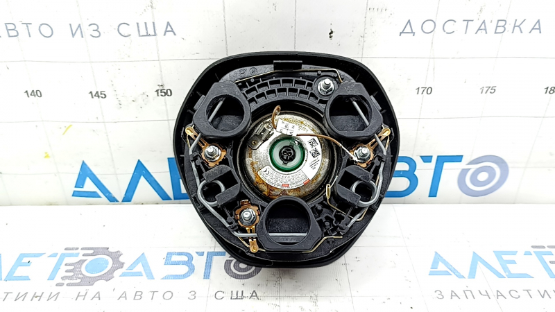 The driver's side airbag in the steering wheel of a VW Tiguan 18-21 is black and scratched.