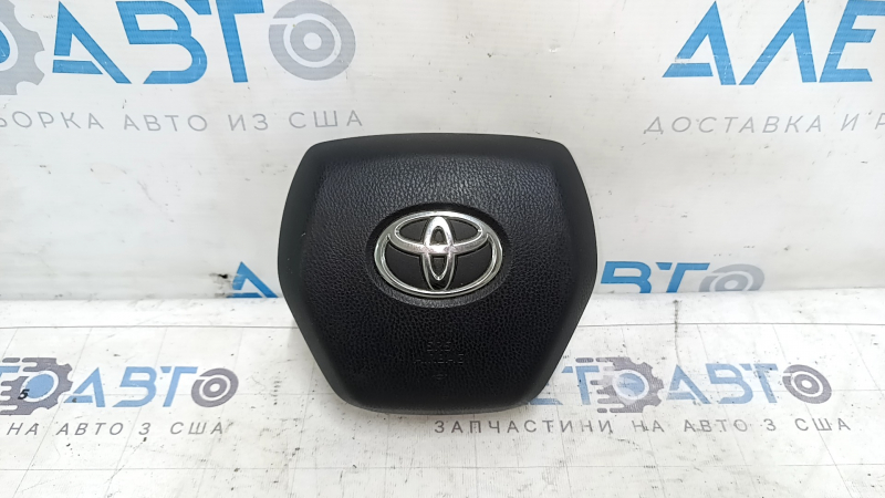 The Toyota Venza 21-24 driver's steering wheel airbag is black and scratched.