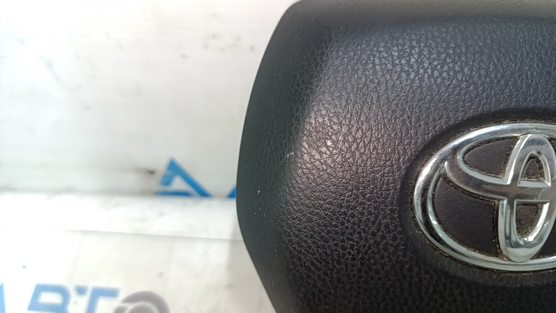 The Toyota Venza 21-24 driver's steering wheel airbag is black and scratched.