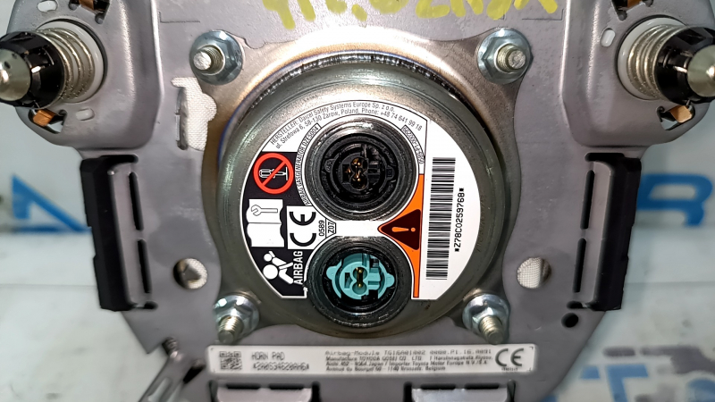 The Toyota Venza 21-24 driver's steering wheel airbag is black and scratched.