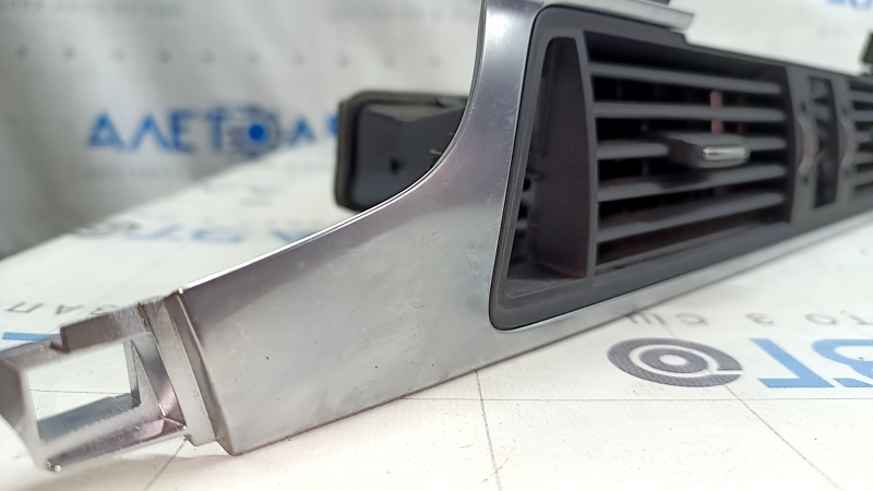 The central air vent for the front panel of the Audi A6 C7 16-18 is black, with a chrome trim, bumps on the chrome, scratches