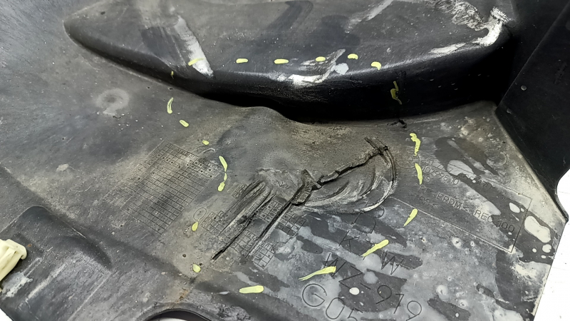 The front right fender liner, lower part, BMW X5 G05 19-23, is dented and torn.