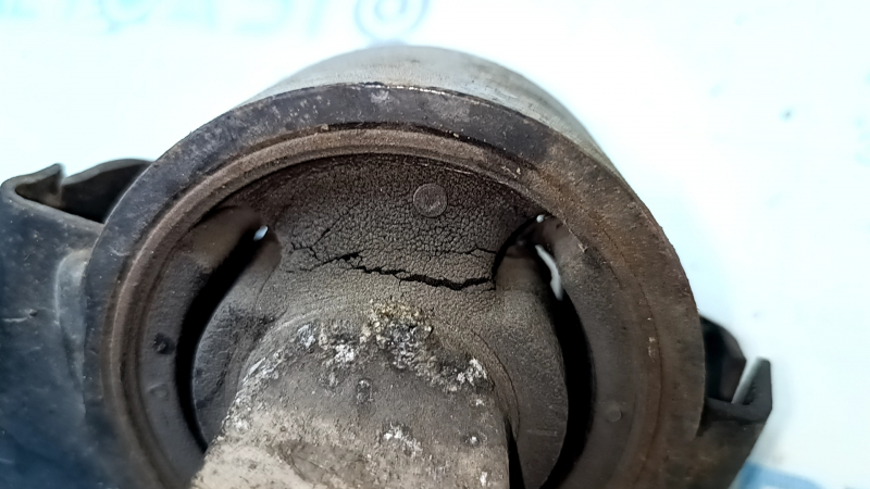 The rear left longitudinal control arm of a Lexus RX350 RX450H 10-15 has a torn silent block and is rusty.