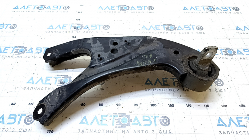 The rear right longitudinal control arm of a Lexus RX350 RX450H 10-15 has a torn silent block and is rusty.