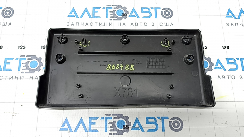 The front license plate plate of a Jaguar F-Pace X761 17-20 Sport is dented and the fasteners are broken.