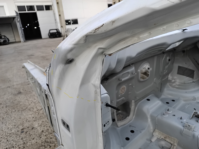 Front left quarter panel of a VW Atlas 18-25, white, dented pillar