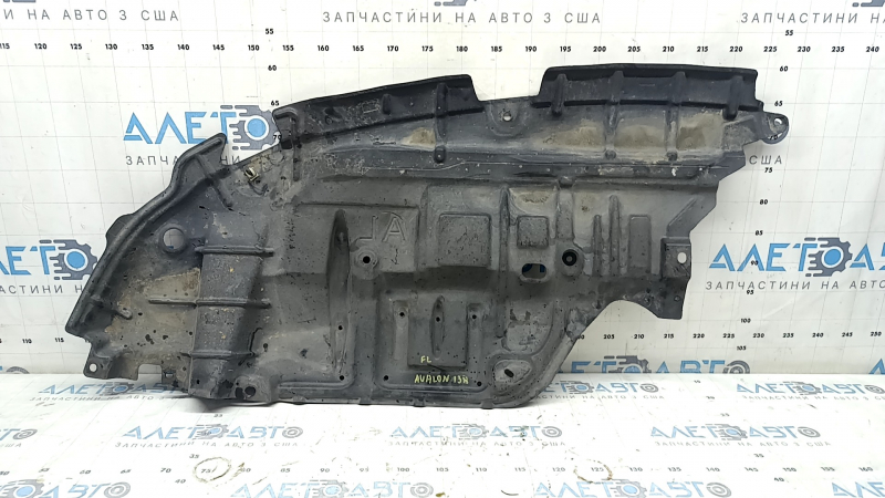 The left engine guard for a Toyota Avalon 13-15 is worn and dented.