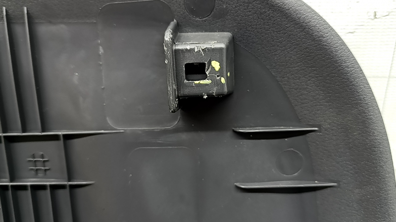 The rear driver's seat cover for a 2022 Hyundai Ioniq is black, with cracks in the fasteners and scratches.