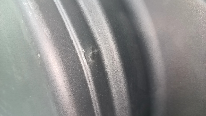 The trunk tray for the spare tire of an Audi A4 B8 08-16 sedan has scratches, a dent, and a tear.