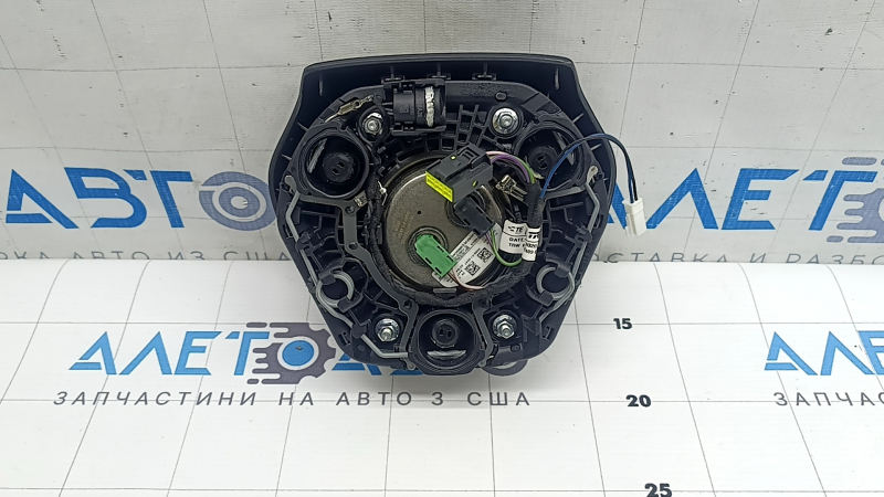 The airbag in the driver's steering wheel of the BMW 3 G20 19-24 is black and scratched.