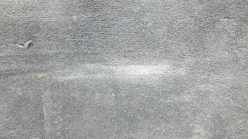 The trunk floor of a Ford Explorer 20-25 is black, worn, scratches on the handle, and a tear.