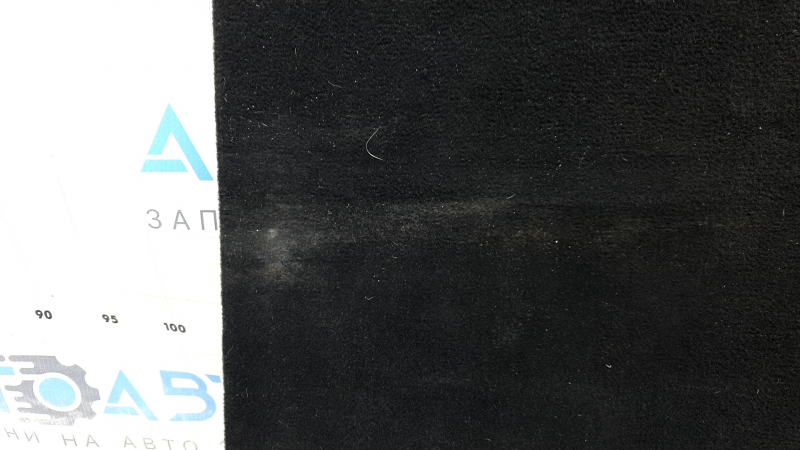 The trunk floor of a Ford Explorer 20-25 is black, worn, scratches on the handle, and a tear.