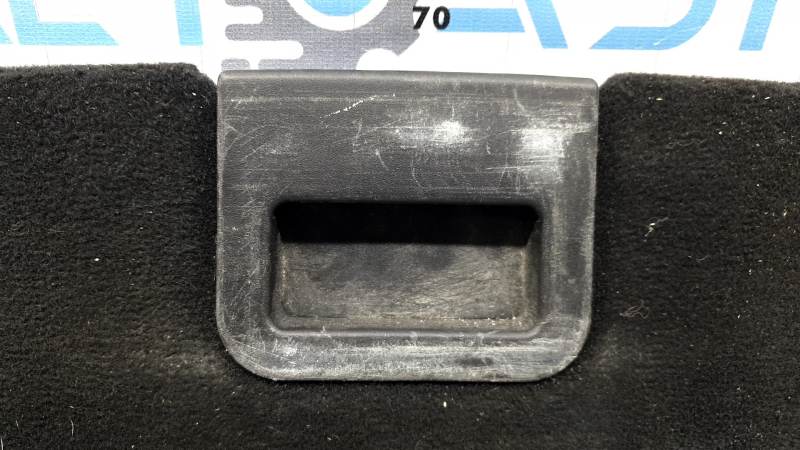 The trunk floor of a Ford Explorer 20-25 is black, worn, scratches on the handle, and a tear.