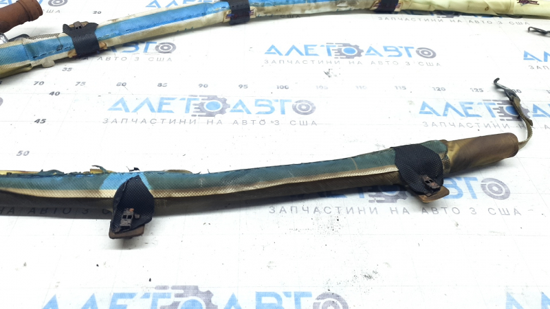 The left side curtain airbag of a BMW 3 G20 19-26 is covered in soot and has a rusty squib.