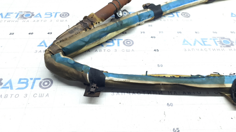 The left side curtain airbag of a BMW 3 G20 19-26 is covered in soot and has a rusty squib.