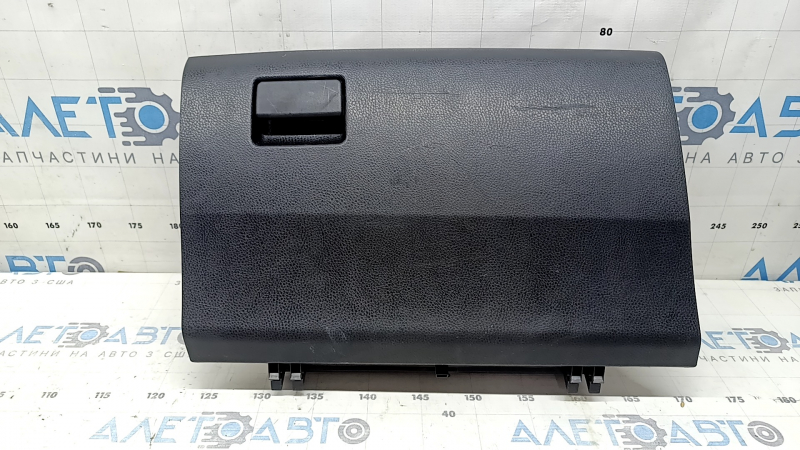 The glove compartment of a Toyota Rav4 2013-2018 is black and has scratches.