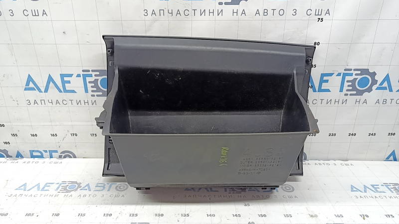 The glove compartment of a Toyota Rav4 2013-2018 is black and has scratches.