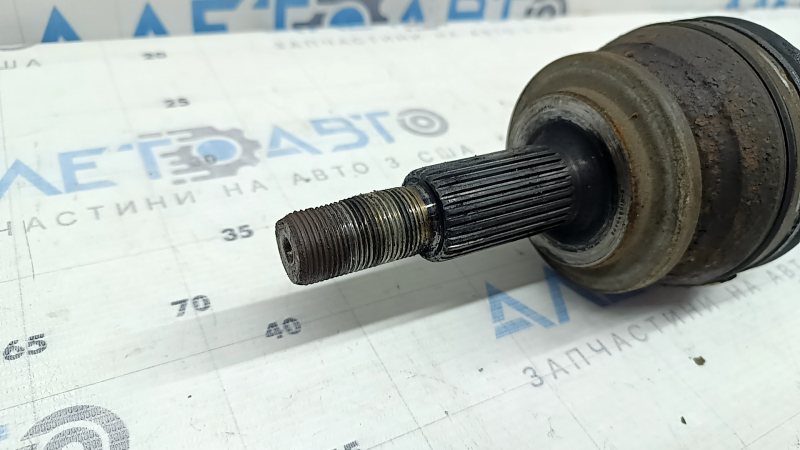The front left half-shaft of a Toyota Rav4 16-18 hybrid is rusty and has a torn inner boot.