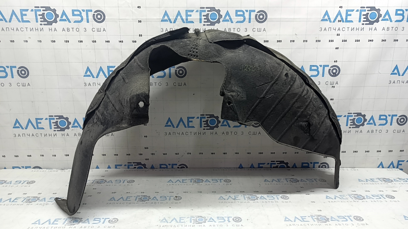 The rear left fender liner of a Kia Sportage 23-26 is dented and torn.