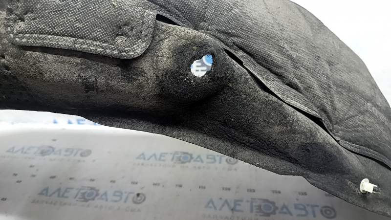 The rear left fender liner of a Kia Sportage 23-26 is dented and torn.