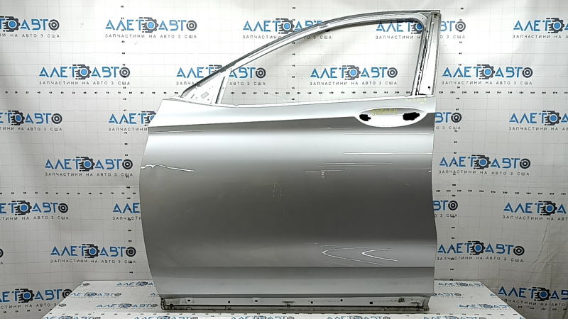 The front left door of an Infiniti QX50 19-25 silver K23 is bare, dents, and the sealant has peeled off.