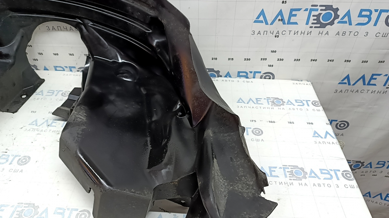 The rear right fender liner of a 19-23 Jeep Renegade is dented and the fastener is torn.