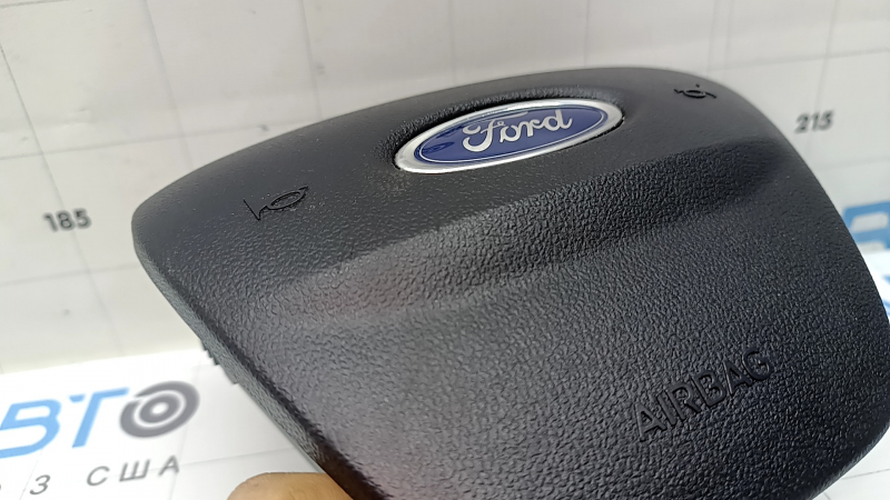 The steering wheel airbag on the driver's side of a Ford Escape MK4 20-26 has scratches.