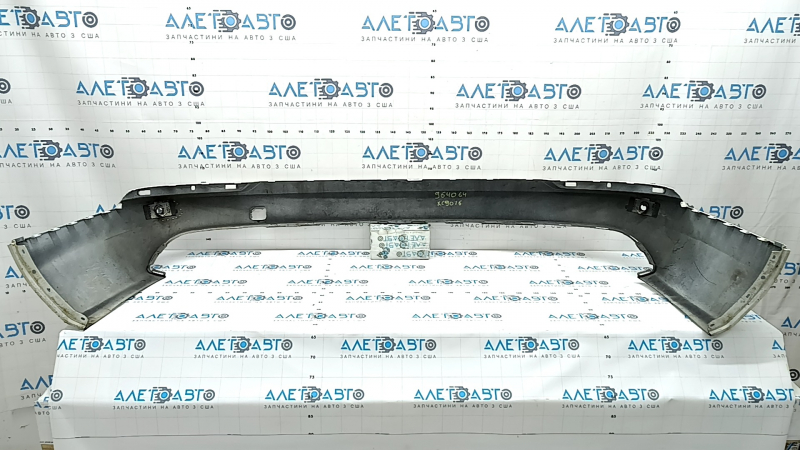The bare lower rear bumper of a Volvo XC90 16-26 for parking sensors, white, the parking sensor mount is broken, dented, and there are cracks in the mounts.