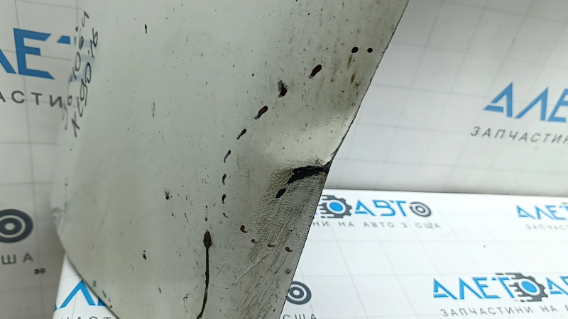 The bare lower rear bumper of a Volvo XC90 16-26 for parking sensors, white, the parking sensor mount is broken, dented, and there are cracks in the mounts.