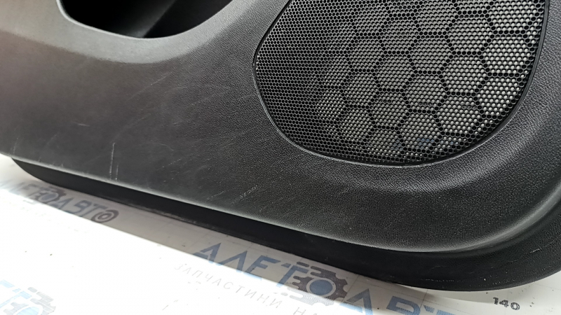 The front left door panel of a Chevrolet Volt 16 is black, with a black leather insert, the armrest is black leather, with a handle, without a trim and buttons, scratches