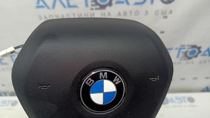 The airbag in the driver's steering wheel of the BMW 3 G20 19-26 is black and scratched.