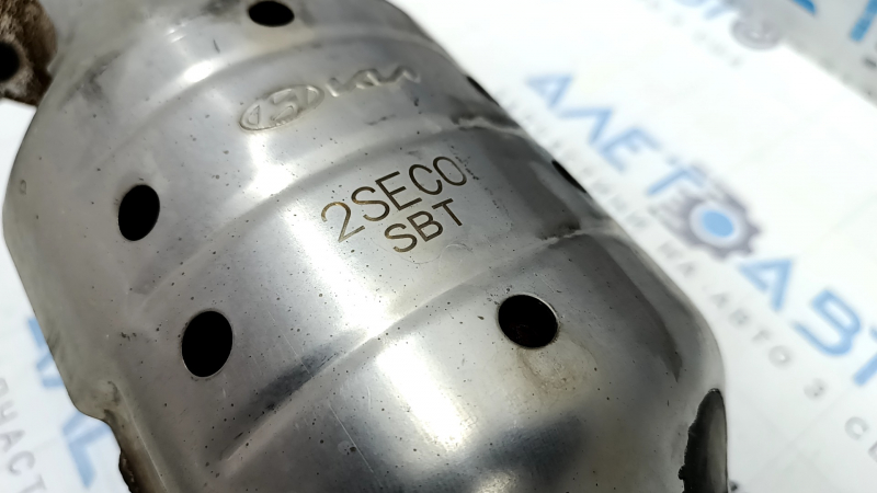 The exhaust pipe, the middle part with the catalytic converter of the Kia Sportage 23-25 2.5, is dented.