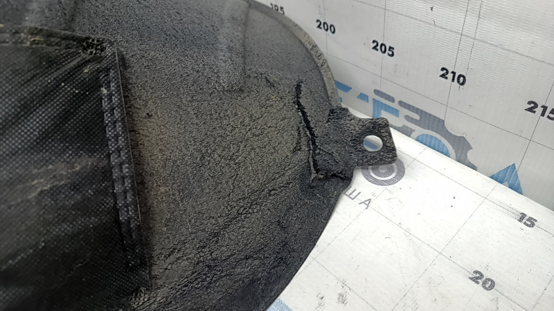The rear left fender liner of a Hyundai Santa Fe 24-26 is torn and dented.